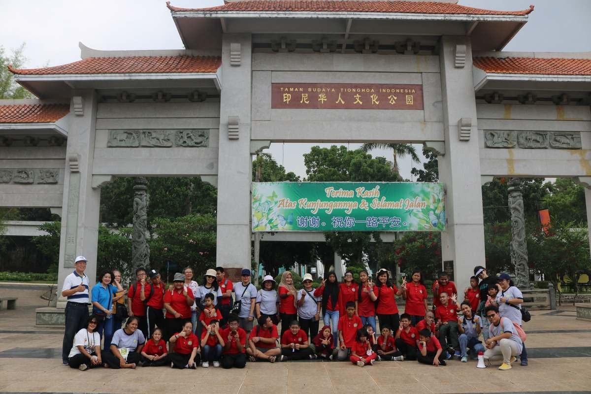 Rombongan siswa dan guru berfoto di depan gapura