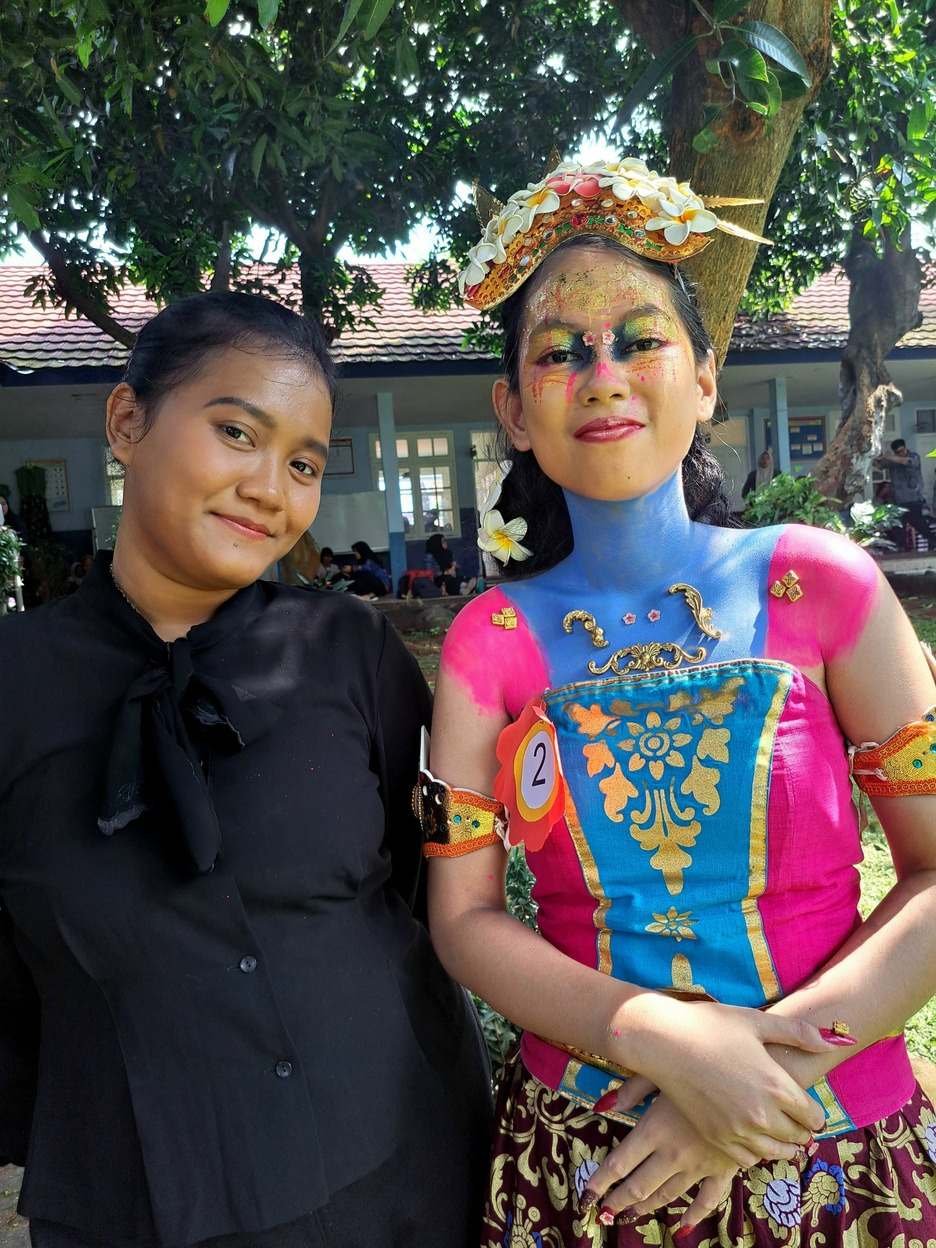 Siswi berkostum tari dan berlukis wajah bersama gurunya