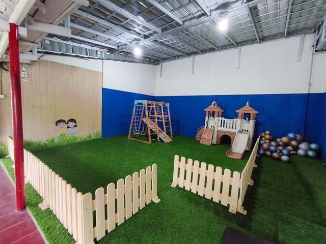 Taman bermain anak dengan rumput sintetis dan pagar kayu