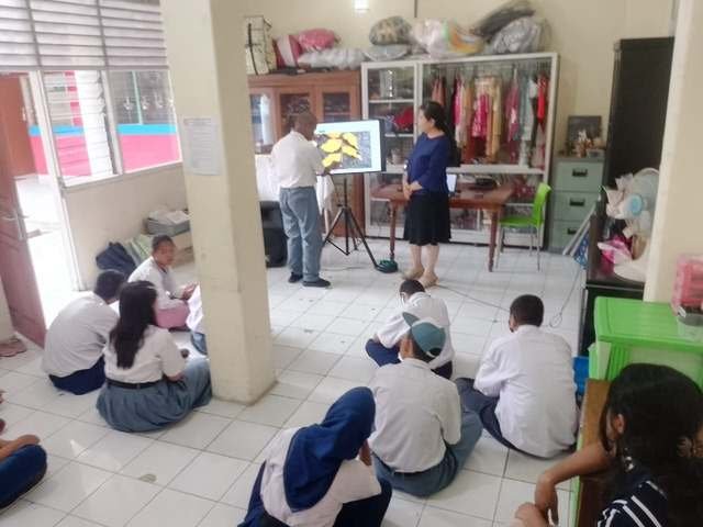 Siswa duduk di lantai menyimak penjelasan di ruang keterampilan